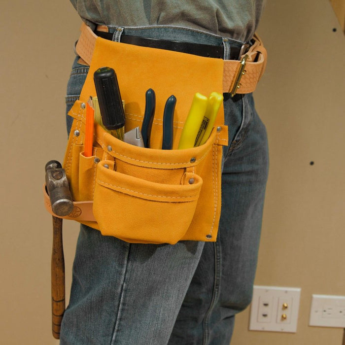 Construction worker with Klein leather tool pouch fill with hammers, pliers, screwdriver, pencil.