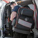 Contractor carrying Klein Tools Tradesman Pro™ Laptop Backpack near utility van
