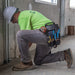 Man screwing metal conduit while wearing Tradesman Pro Modular Tool Pouch