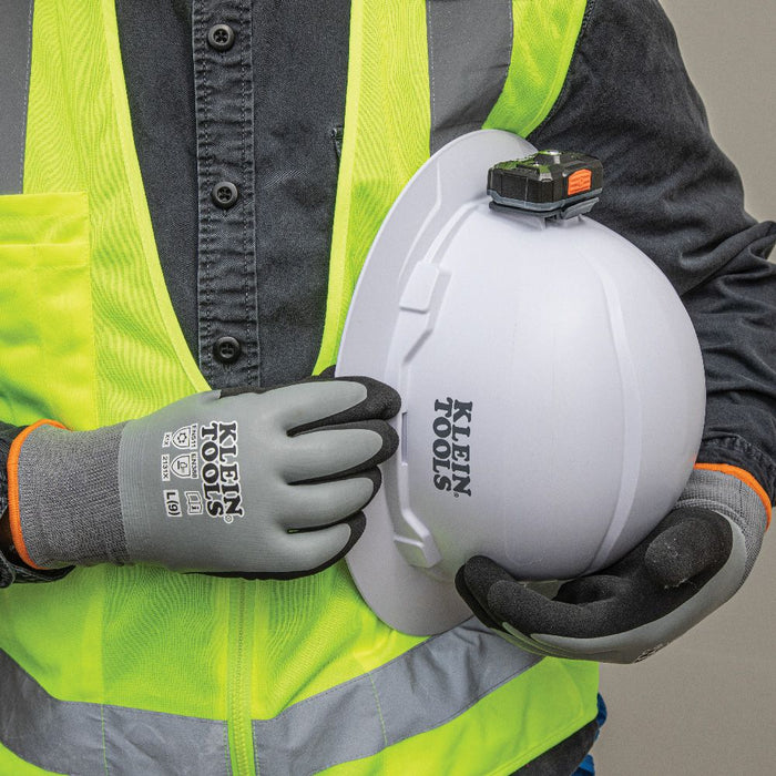 Klein Tools Thermal Dipped Gloves holding a hard hat