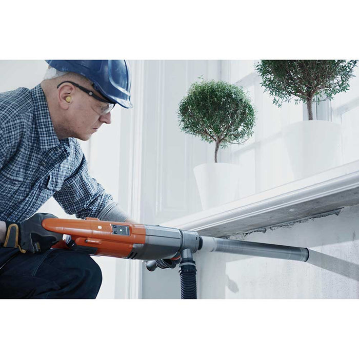Man drilling into concrete wall with Husqvarna DM 220 Handheld Core Drill