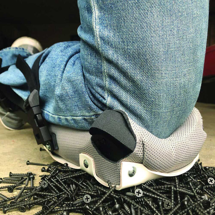Kneeling on a pile of screws to show the strength of PorKnee 0714 knee pads