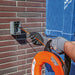 Inserting Klein Tools nylon tip of fish hook through outdoor brick wall
