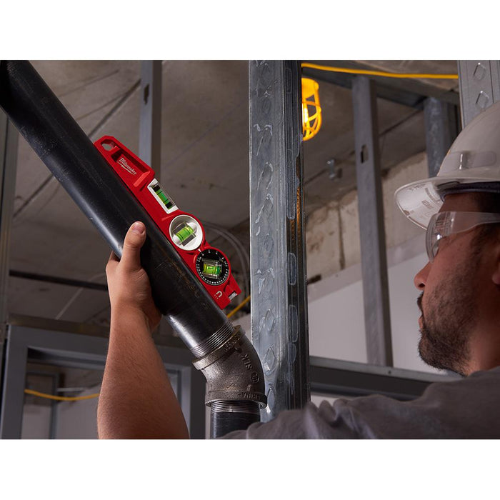 Professional measuring the angle of a pipe installation with Milwaukee torpedo level 