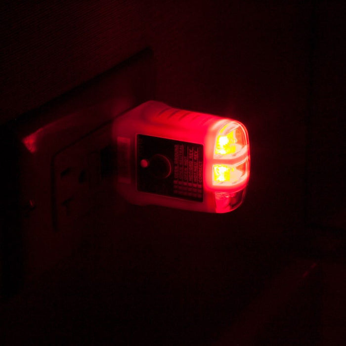 Klein Tools RT210 GFCI Tester plugged into outlet showing red light in the dark